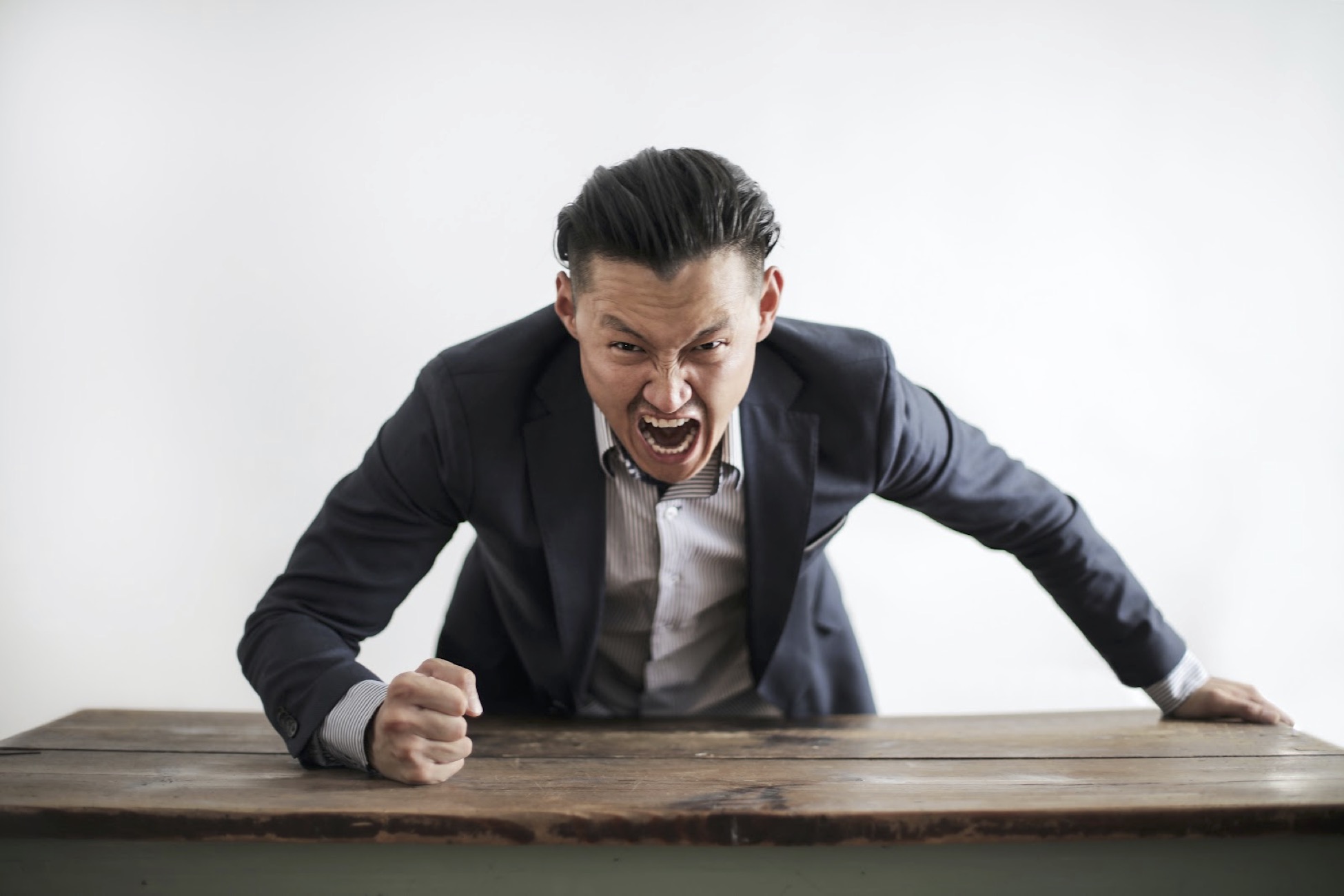 Man angrily slamming fist on a desk