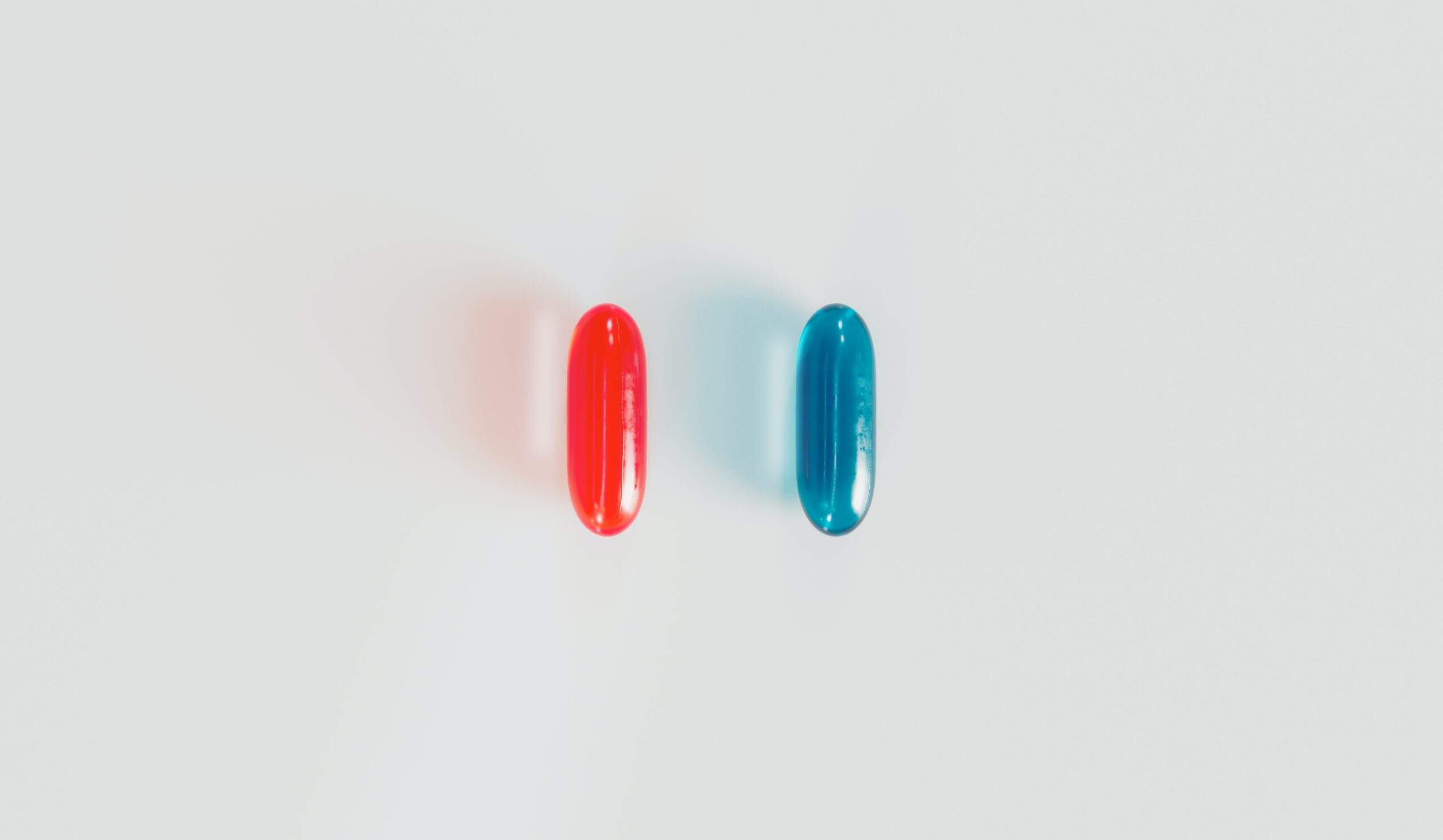 Picture of a red pill parallel to a blue pill.