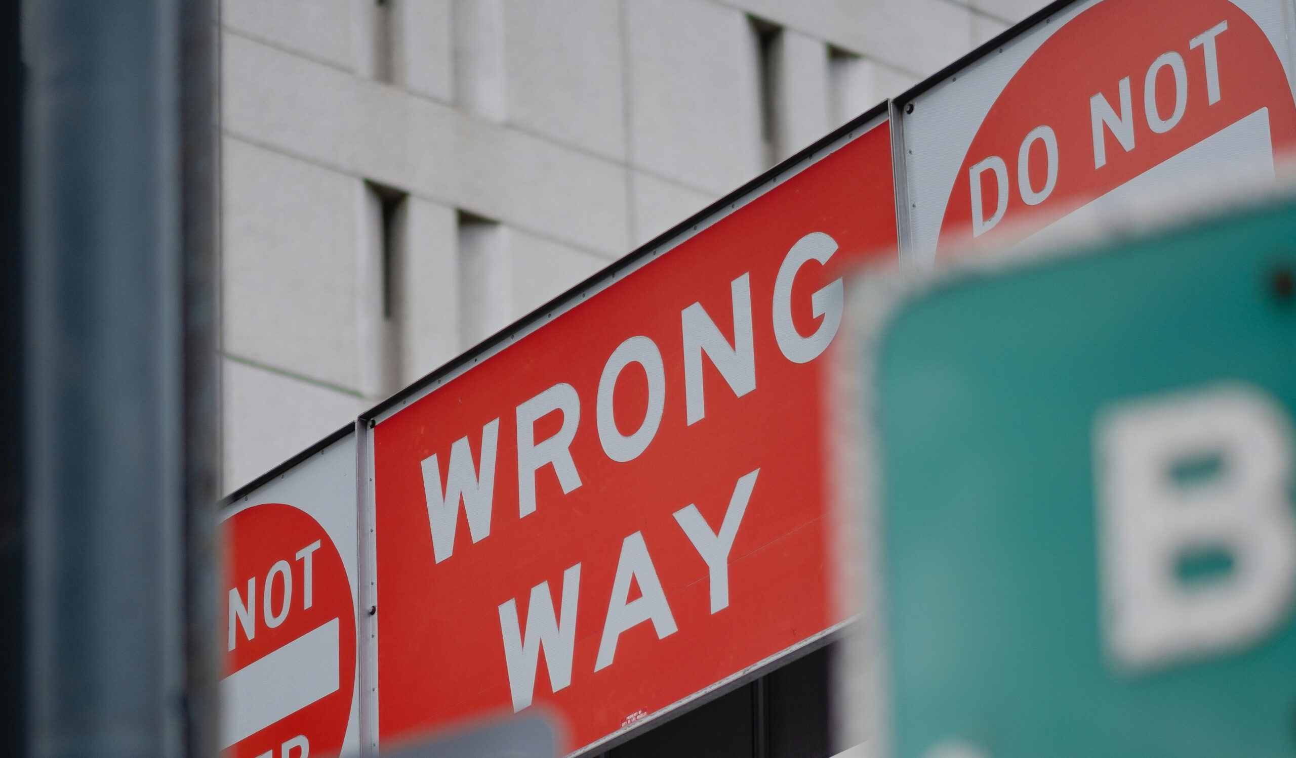 Picture of a street sign in a city indicating "wrong way" and "do not enter."