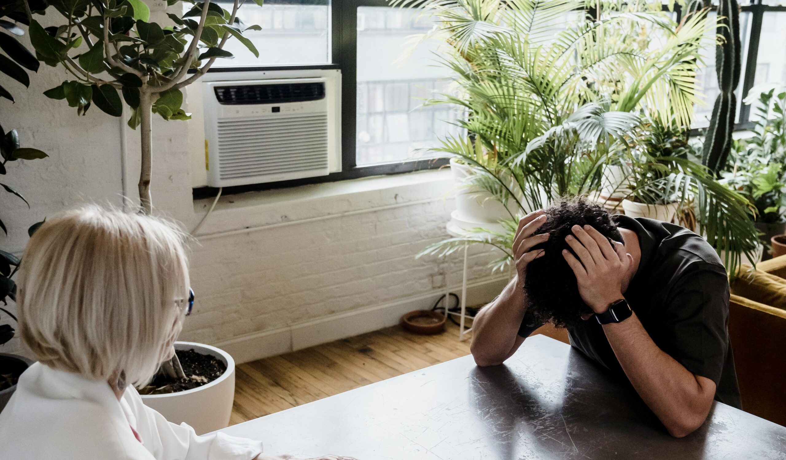 Picture of a man with this head down, seemingly distraught.